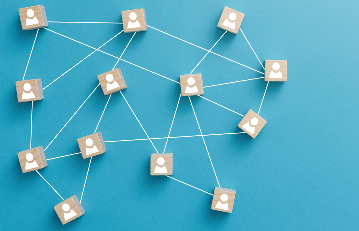 Wooden blocks connected together on blue background. Teamwork, network and community concept. 2023/08/shutterstock_1682046394-e1692494560551.jpeg 