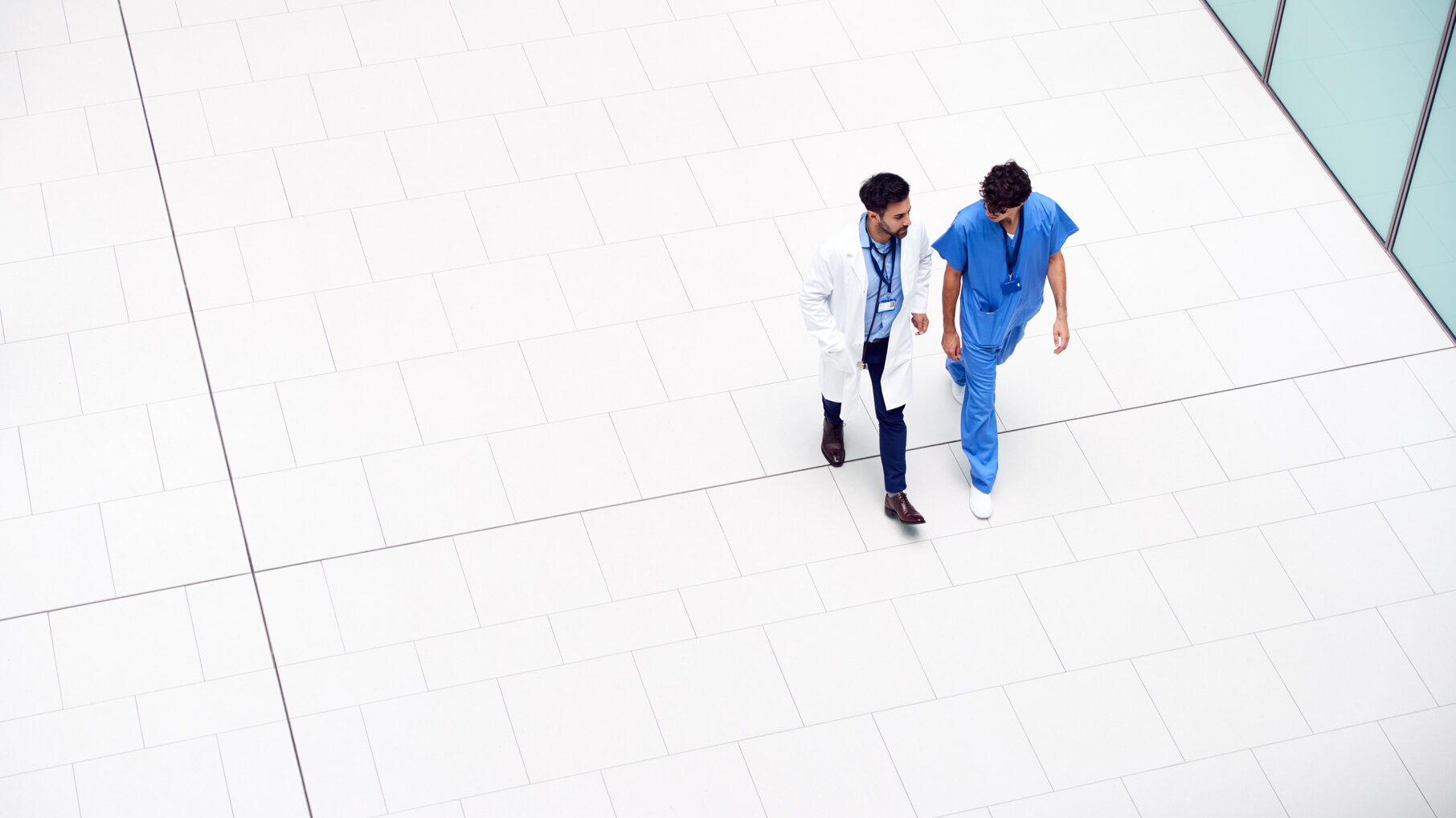 Overhead View Of Medical Staff Talking As They Walk Through Lobby Of Modern Hospital Building 2024/11/AdobeStock_305700676-e1732728154575.jpeg 